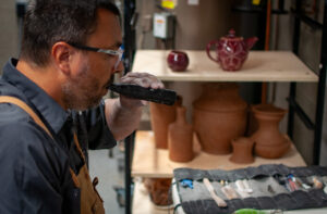 Man Vaping on Mixturus while doing pottery