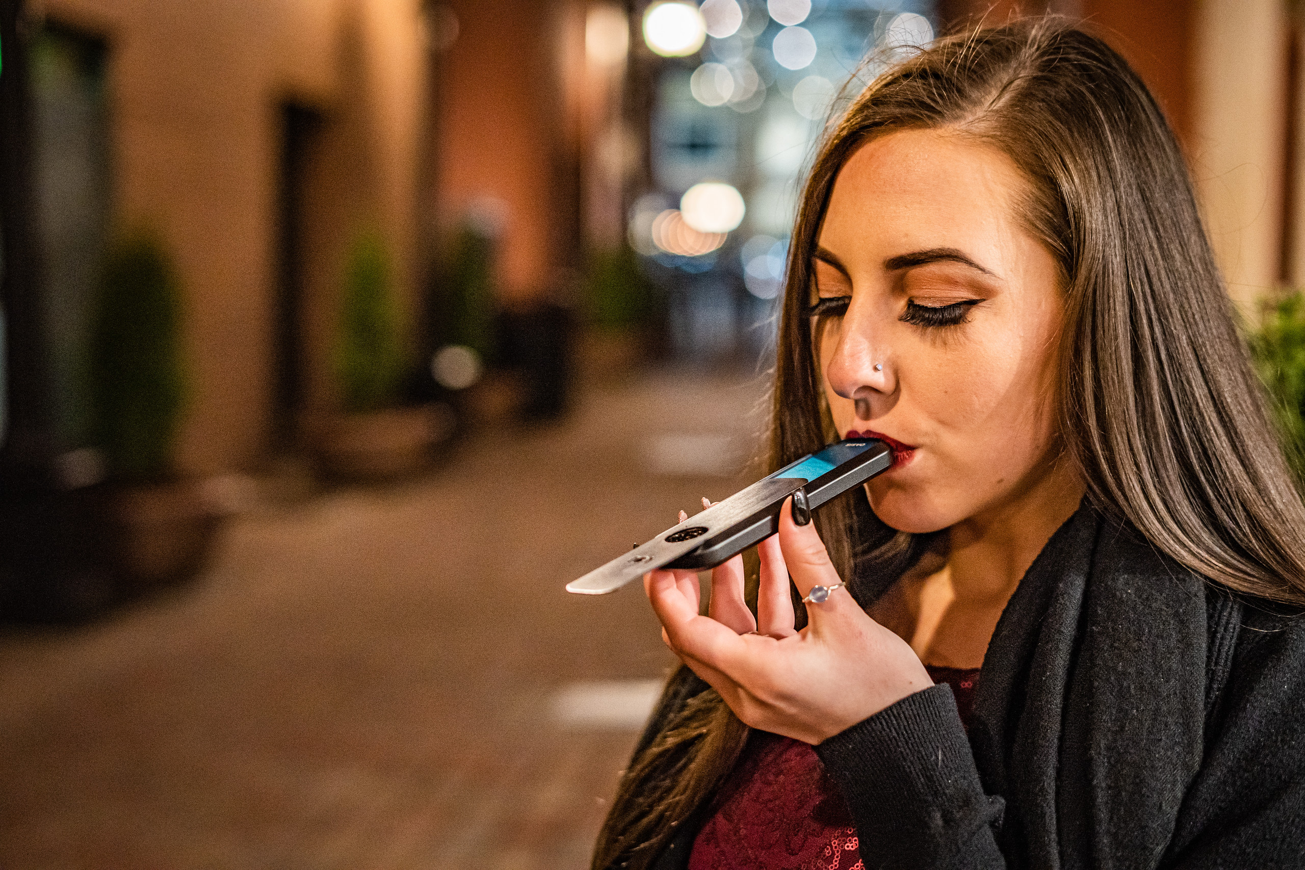 The OASIS pipe in use — nightlife setting with city bokeh