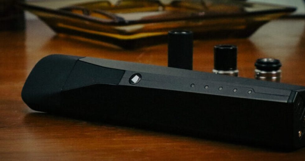 Black vaporizer on wooden table